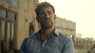 Jack Ryan with dirty face sitting in blue button-up shirt in Jack Ryan: Ghost War