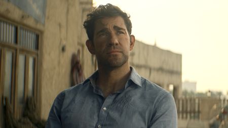 Jack Ryan with dirty face sitting in blue button-up shirt in Jack Ryan: Ghost War