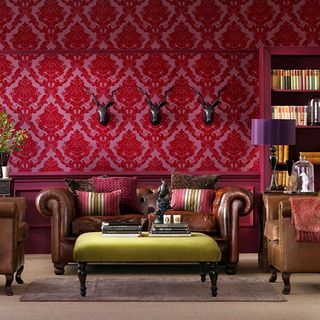 living room with damask wallpaper and sofa with cushions