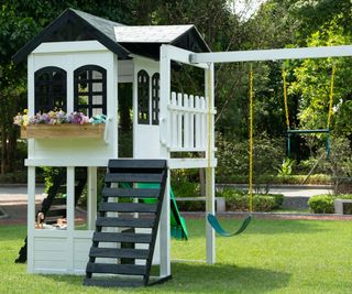 large outdoor play area with playhouse and swings