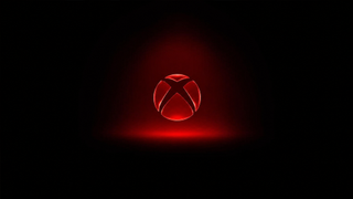 A glowing red Xbox logo sits centered on a black background, surrounded by a soft red light with a faint reflection beneath it.