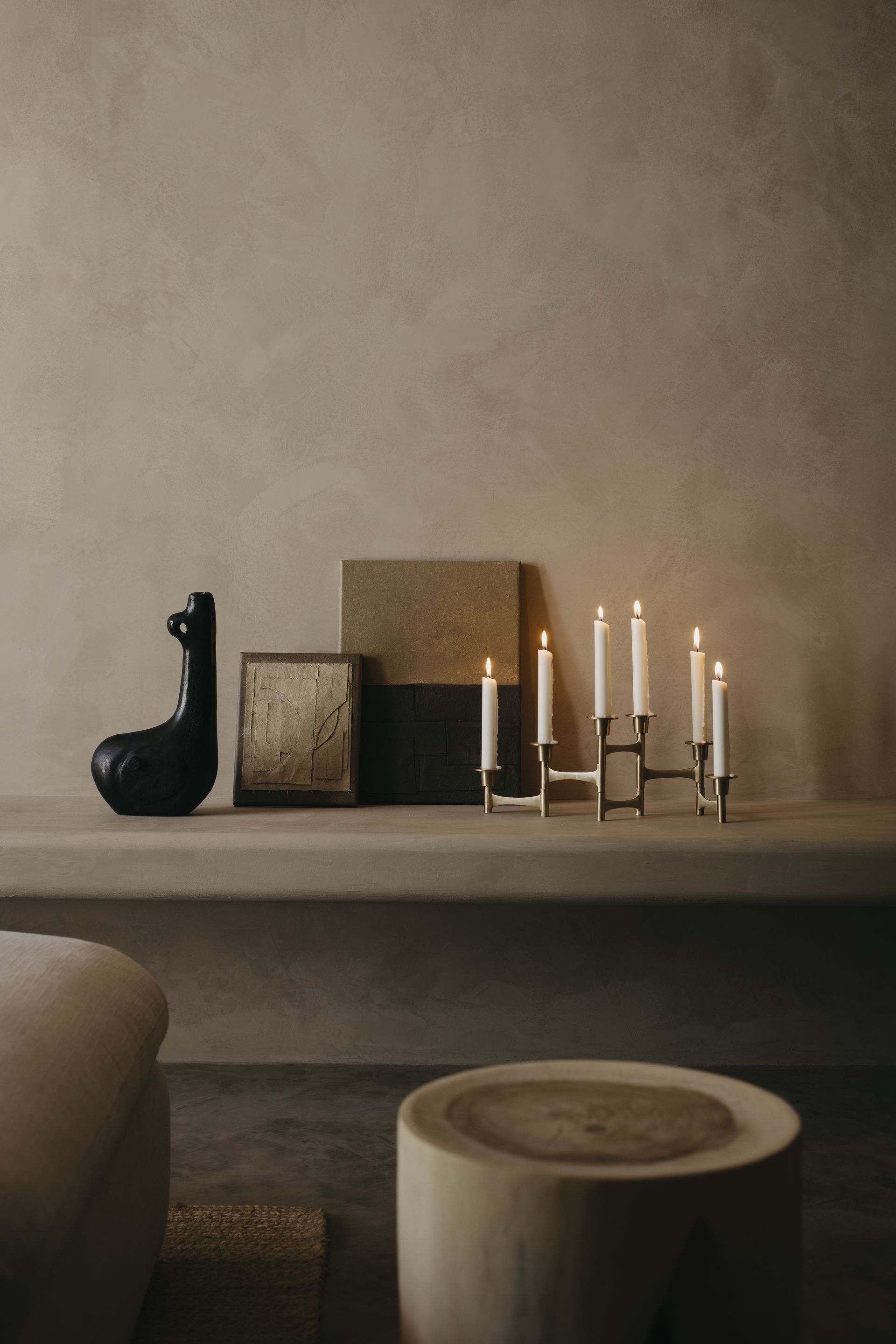 A corner in the home with candles, a decorative and stools