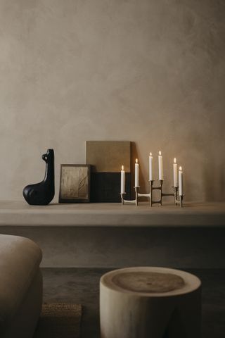 A corner in the home with candles, a decorative and stools