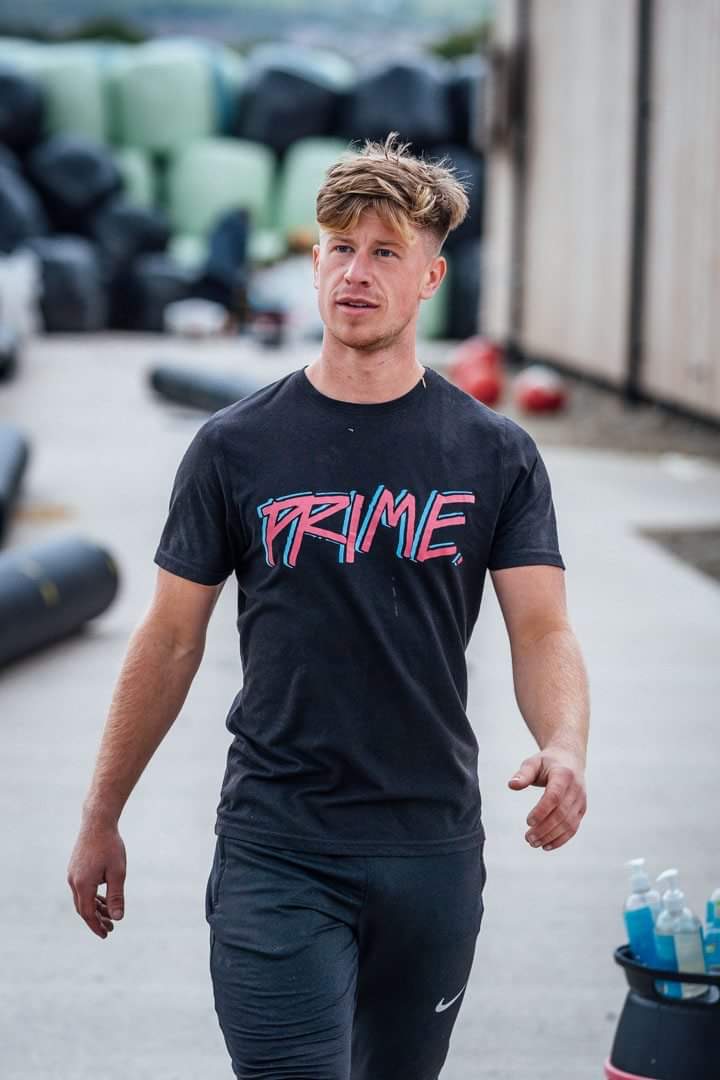 man in black tshirt with prime written on it walking toward the camera
