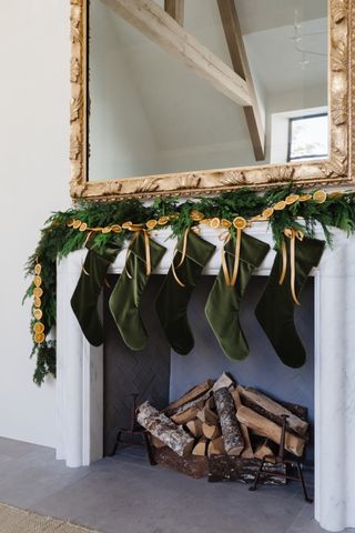 Christmas garland and stockings on mantelpiece by Marie Flanigan