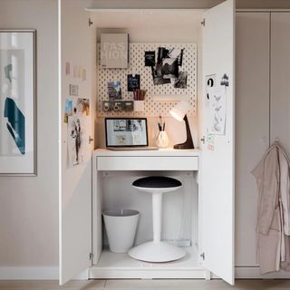 A photo of a white desk in a white dresser closet