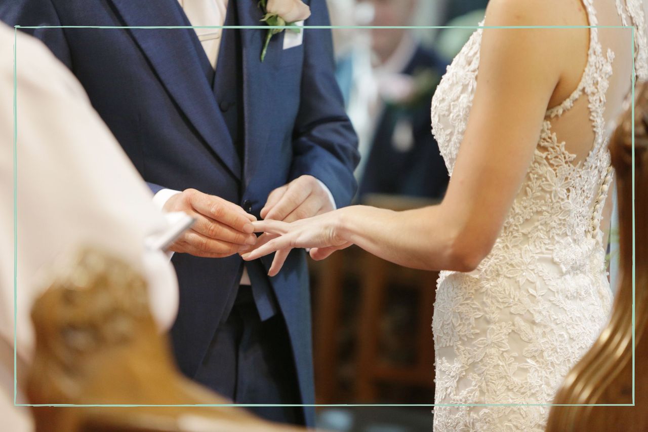 A groom putting a wedding ring on a bride&#039;s finger