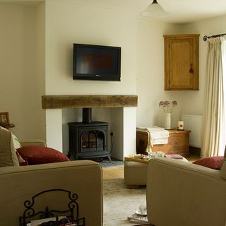 living room with cream wall and tv on wall with fireplace