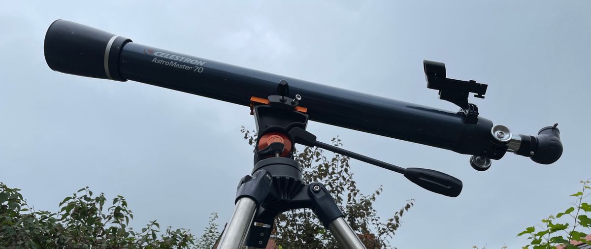 Celestron astromaster 70az telescope profile view against a cloudy sky