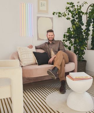 bobby berk sitting in neutral living room with neon light feature