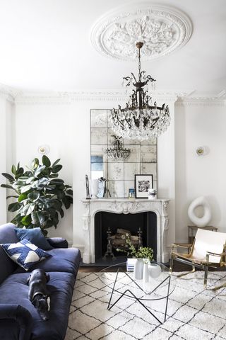 white living room in Victorian home with blue sofa and Berber style rug