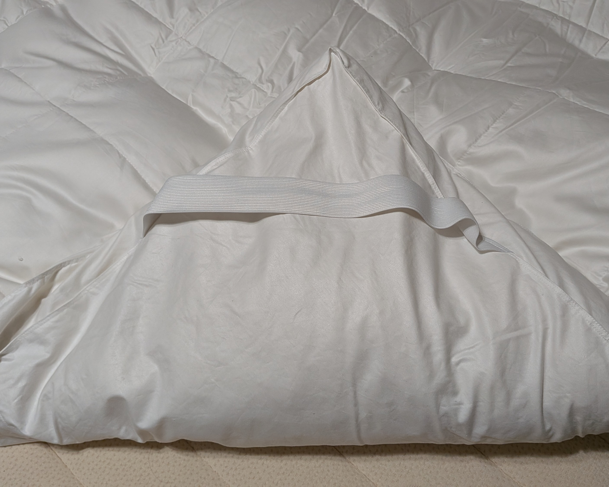 Stretchy strap on the Avocado Down Mattress Topper.