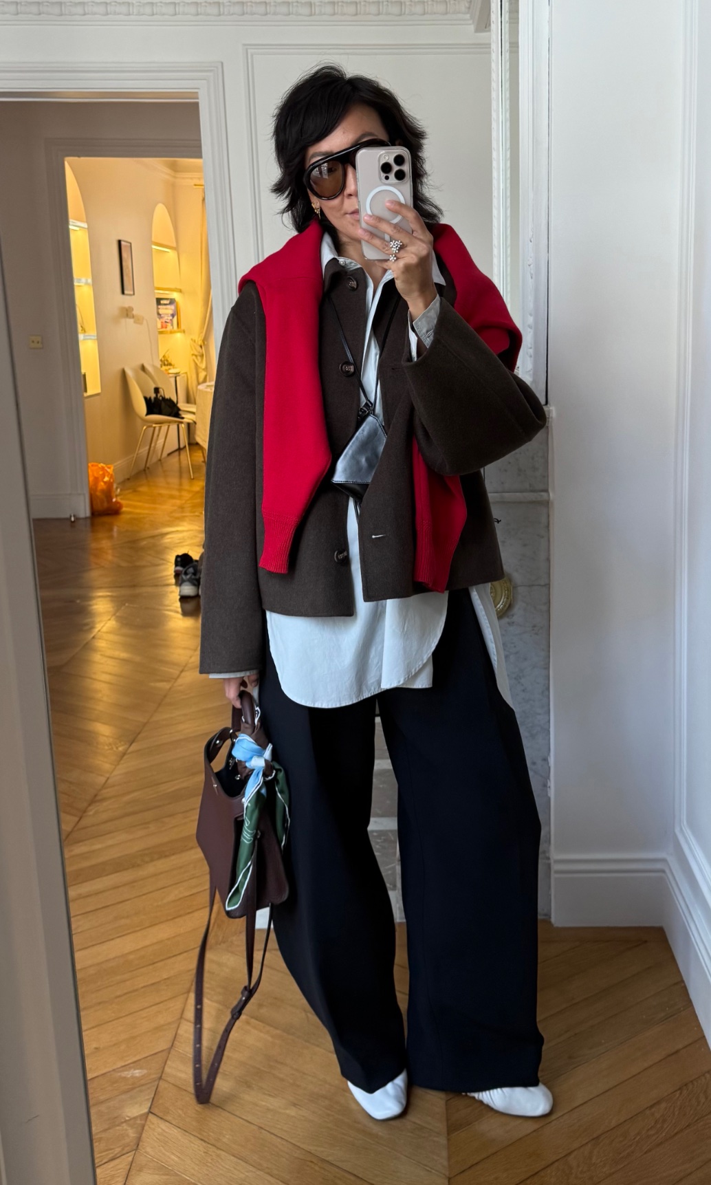 Irene Kim wearing a jacket, a sweater, pants, flats, and a bag