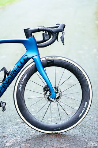 A close up of a Scope Artech 6.A front wheel on a blue Pinarello Dogma road bike.