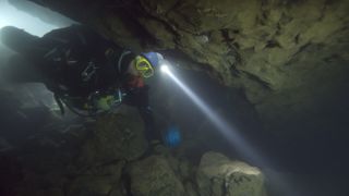 A diver searching between rocks on The Rescue