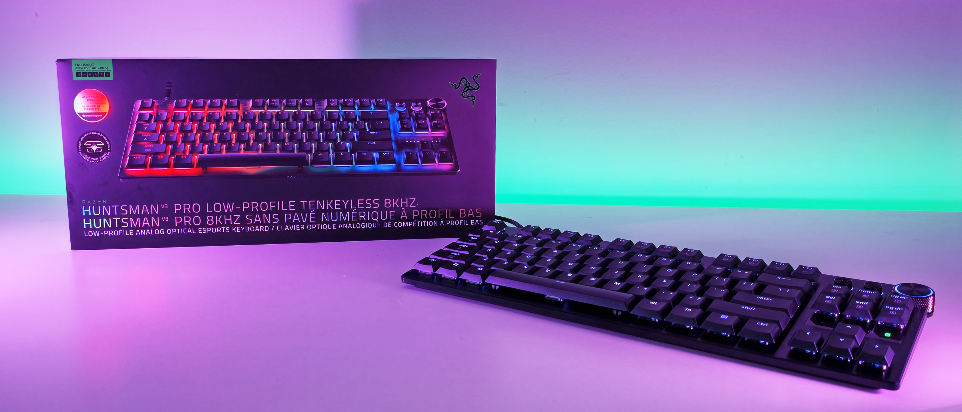 Razer Huntsman V3 Pro Low-Profile Tenkeyless keyboard displayed next to its official retail packaging box in a wide desk shot.