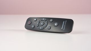 Panasonic SC-HTB100 remote on white surface