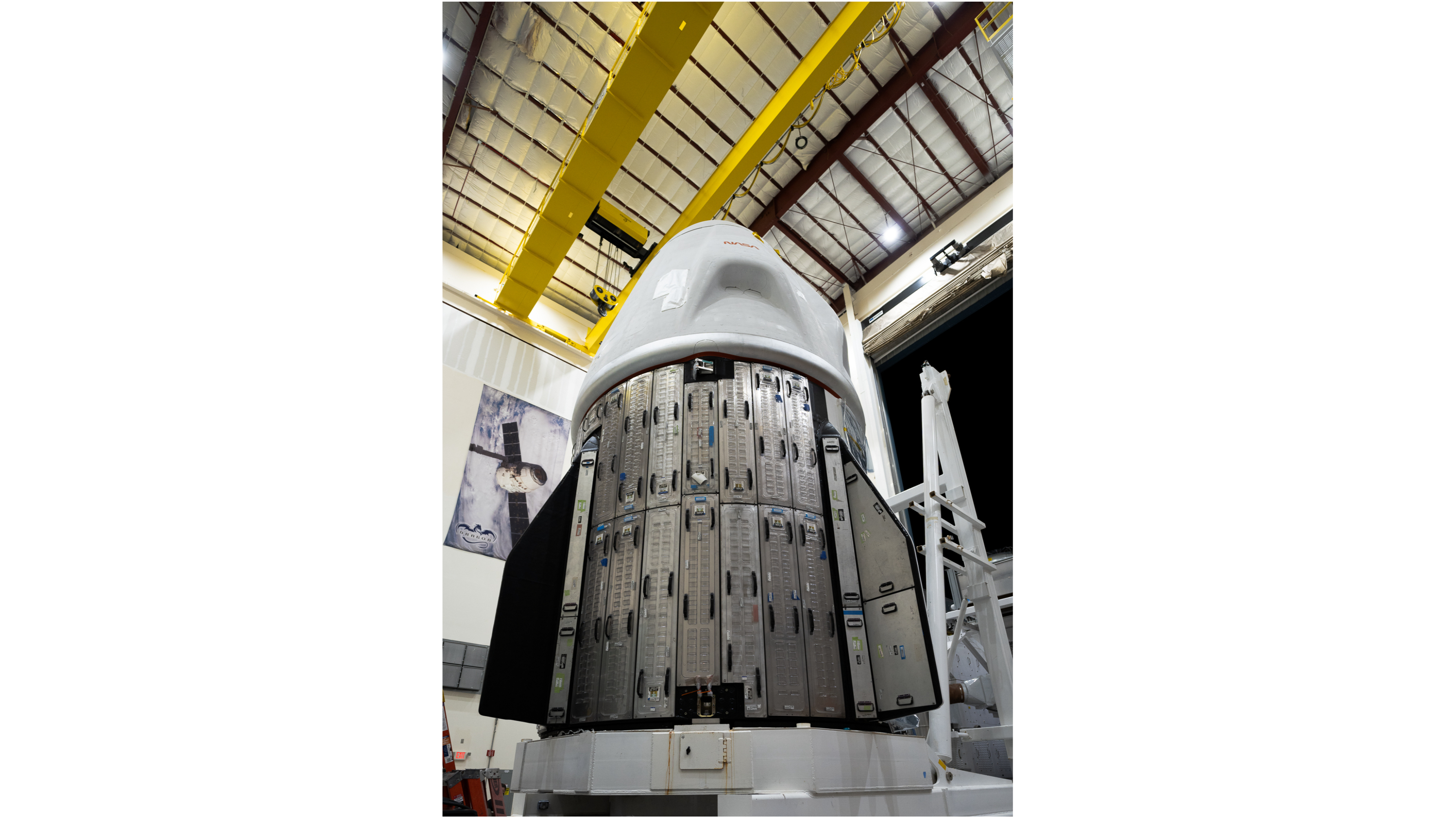 una cápsula espacial en blanco dentro de un hangar por la noche