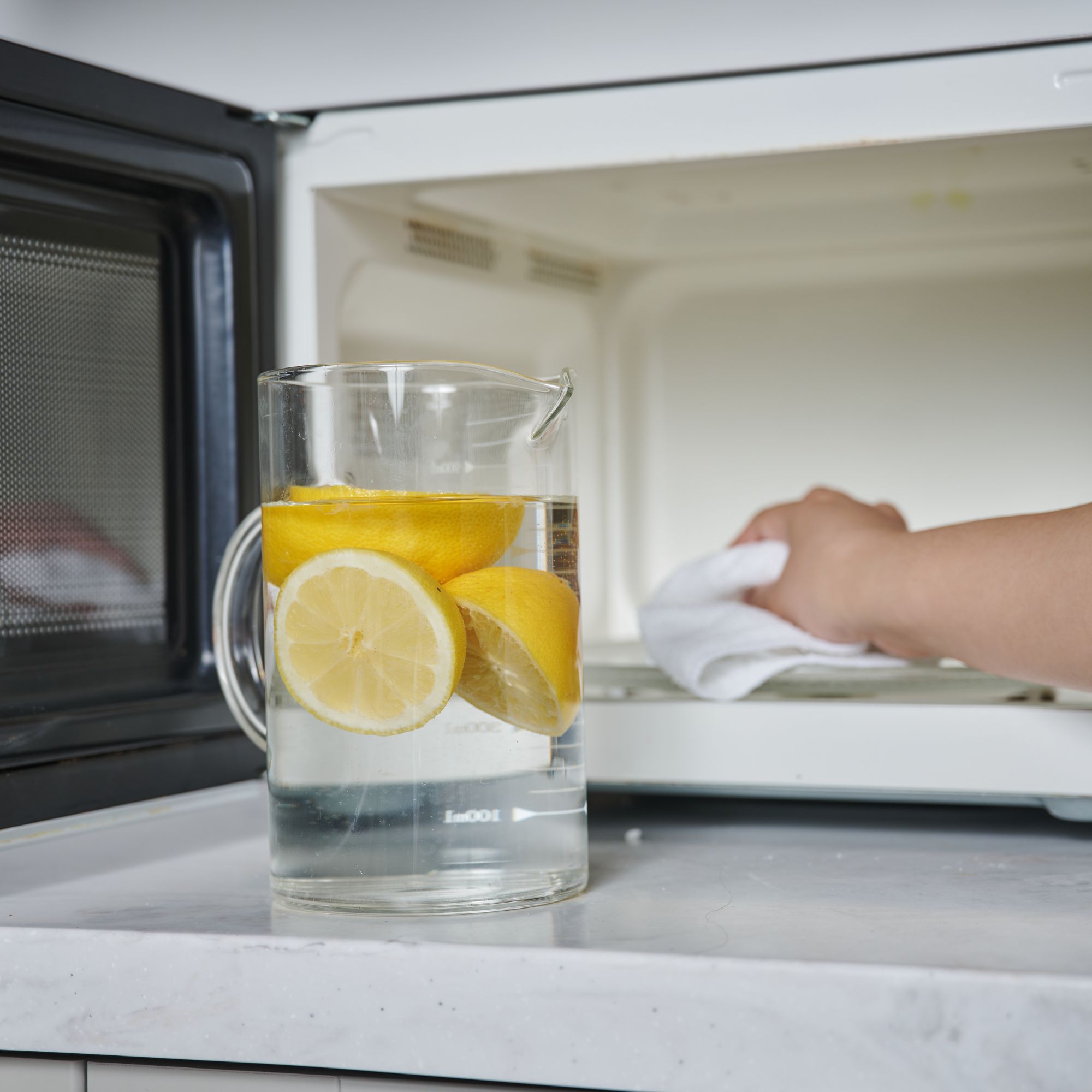 Jug of water and lemons in front of a microwave
