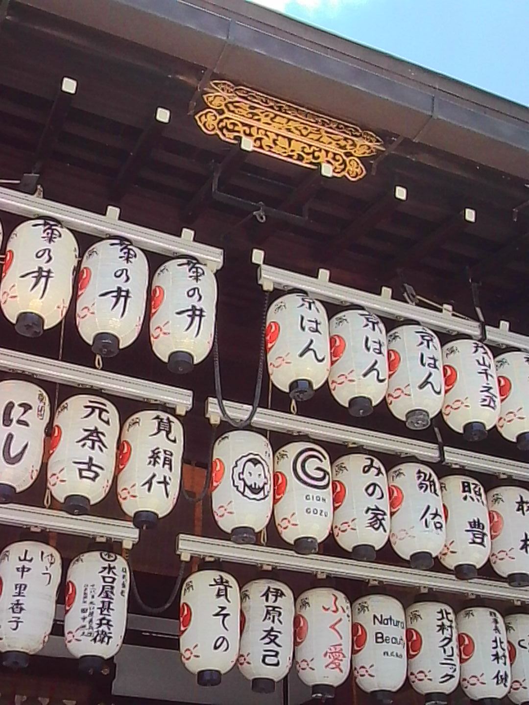 Close-up of rows of white paper lanterns hanging at a Japanese shrine.
