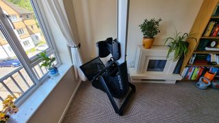 The Aviron Strong Series Rower stored upright in the corner of the living room