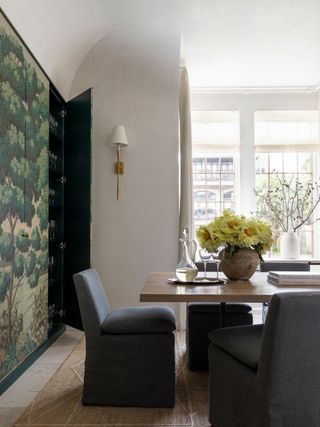 a dining room with storage covered in a woodland wallpaper mural