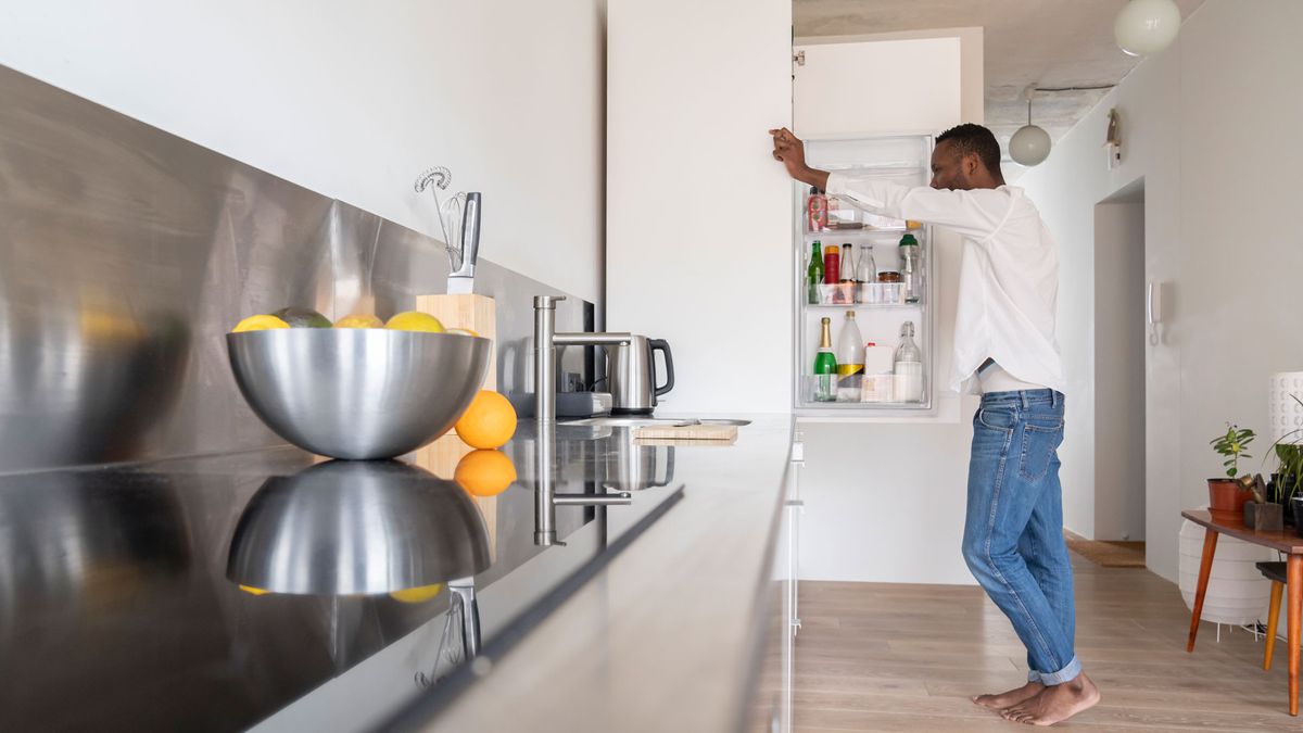 How to buy the right refrigerator for you online: Image shows man looking inside refrigerator