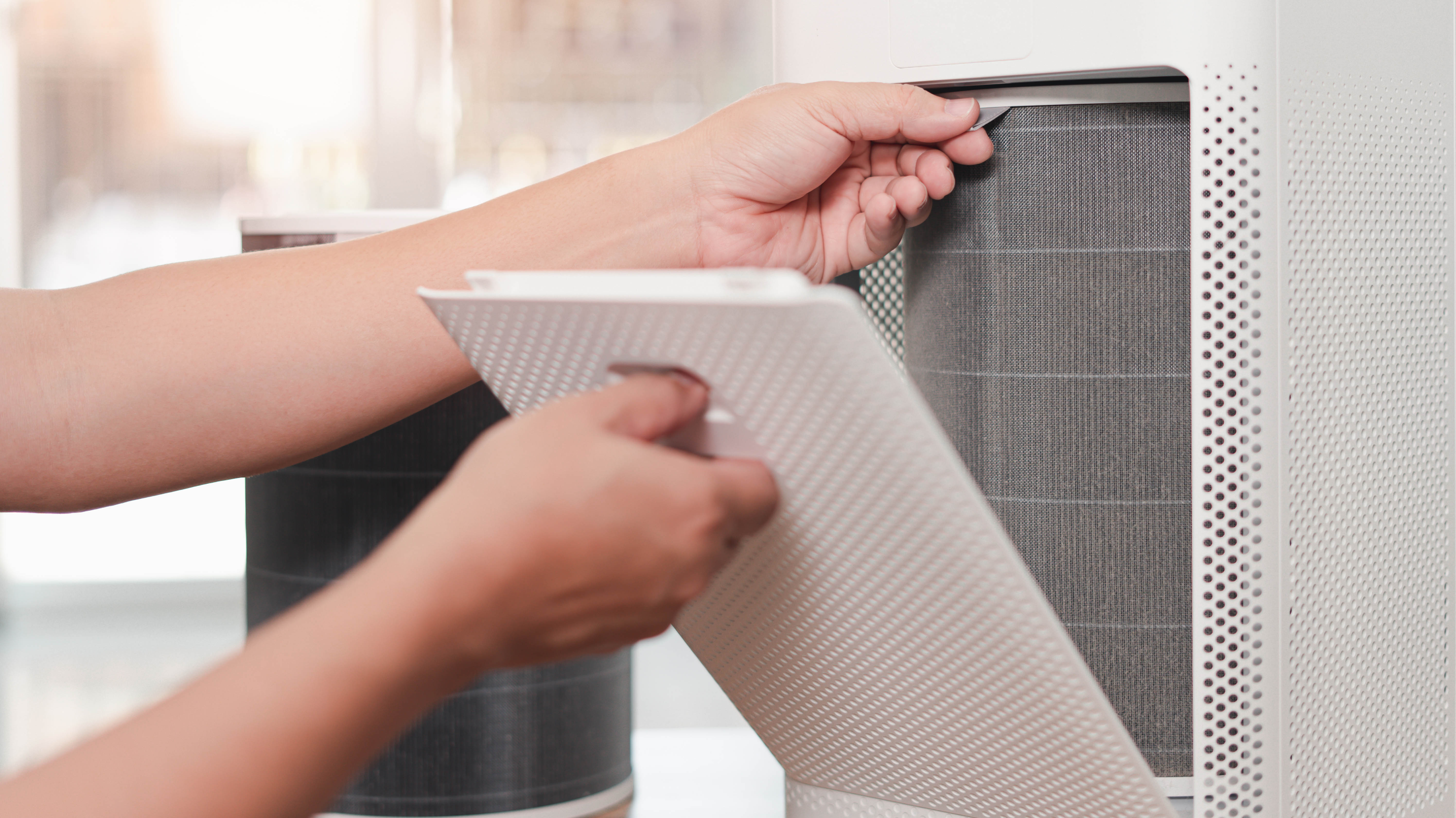 An air purifier being opened to reveal the filter