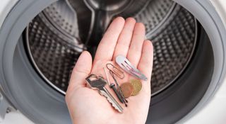Person holding metal objects found in washing machine in the palm of their hand