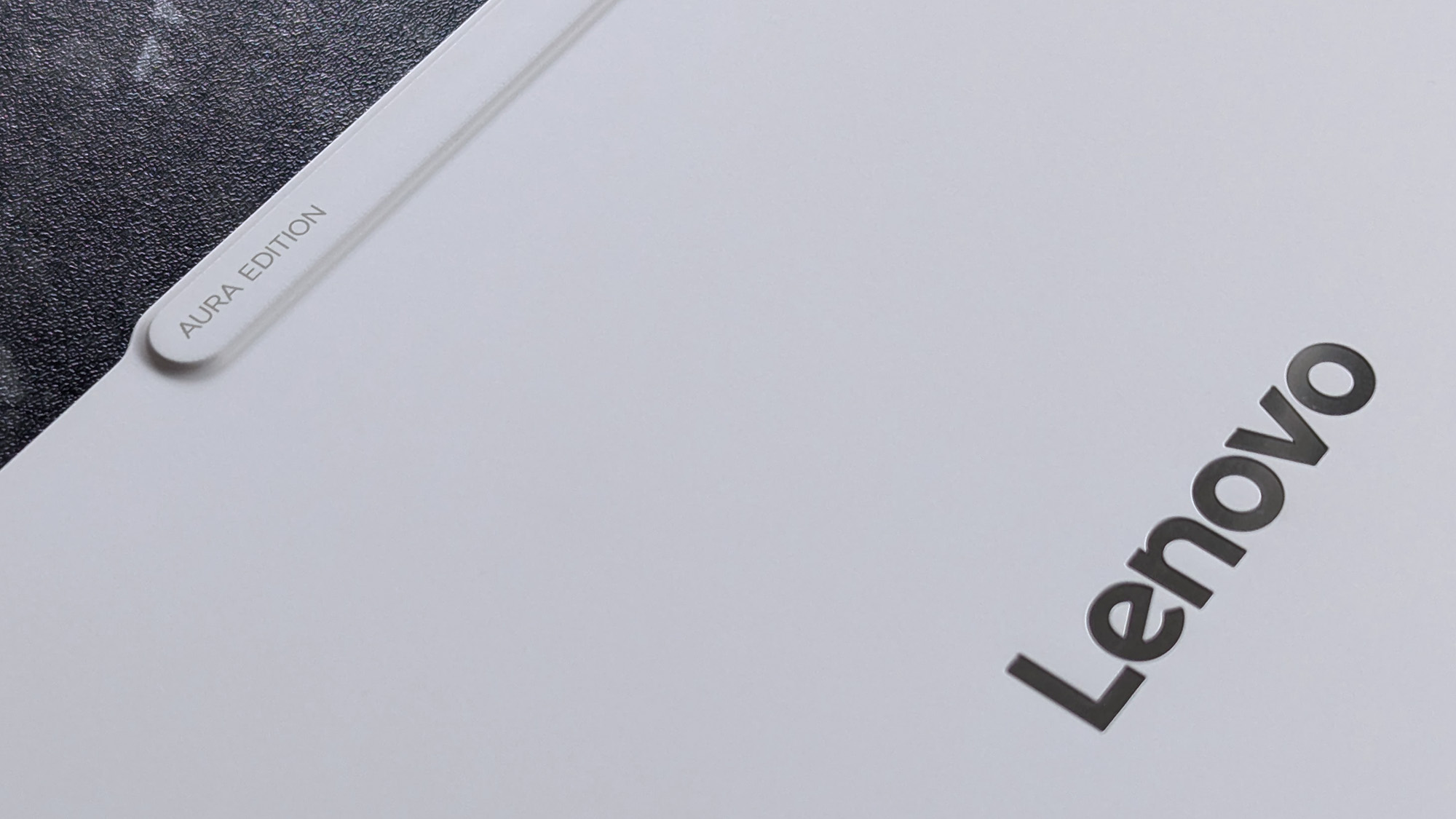 Close-up of a Lenovo Yoga Slim 7i Ultra (Gen 11) Aura Edition laptop lid with "AURA EDITION" marked in small text.