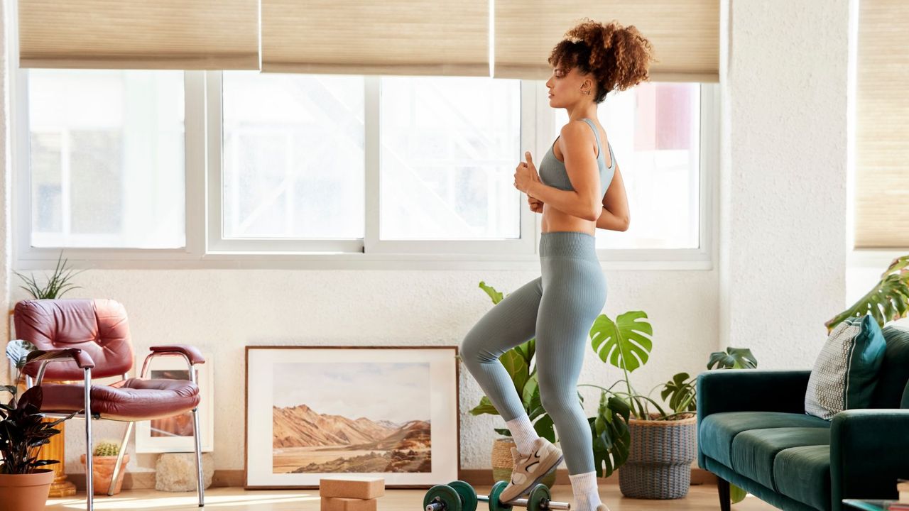 A woman doing an indoor step workout in her living room