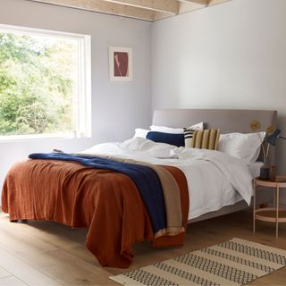 White bedding with orange throws on top