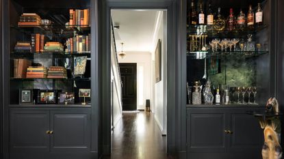 black home bar with mirrored shelves and lighting