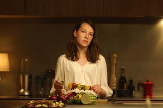 ANNES ELWY in THE FEAST (2021), holding a skewer with vegetables on it