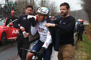 TotalEnergies' French rider Thomas Gachignard (C) drinks from a bottle as the race is neutralised due to weather during the 4th stage of the Paris-Nice cycling race, 163,4 km between Vichy and La Loge des Gardes, on March 12, 2025. (Photo by Anne-Christine POUJOULAT / AFP)