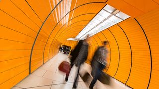 Office workers walking down orange tunnel