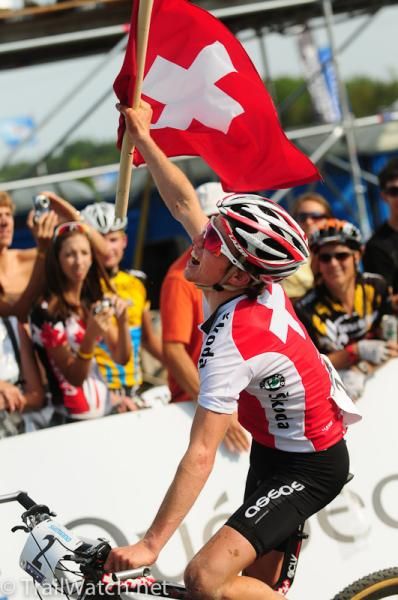 Mathias Fluckiger (Switzerland) proudly waves the Swiss flag before the fans