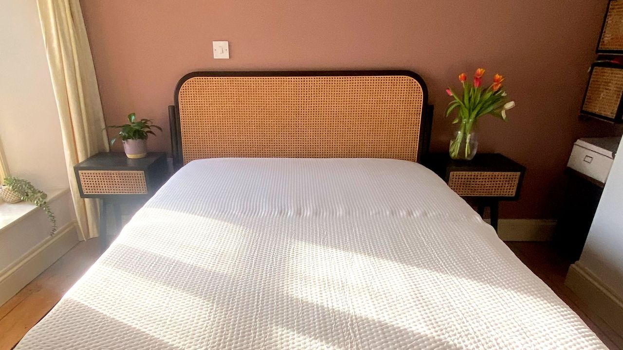 The Emma Hybrid Original mattress being tested in a bedroom with a wooden floor