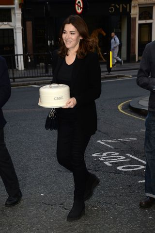 Nigella Lawson carrying a cake.