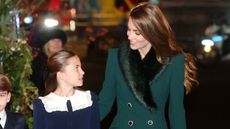 Princess Charlotte of Wales and Catherine, Princess of Wales look at each other as they arrive to attend the 'Together At Christmas' Carol Service