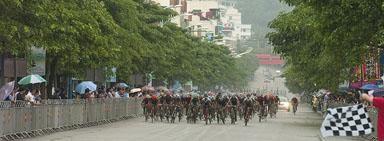 The peloton charge to the line in Chengmai in slippery conditions.