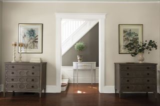 An entryway with greige walls and two matching credenzas either side of the entryway