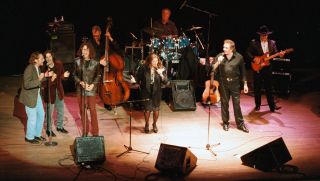 Johnny Cash and June Carter Cash perform onstage with their band, including Dave Roe on bass, W.S. Holland on drums and Bob Wootton on guitar in 1994 in Los Angeles, California.