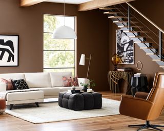 living room with brown walls and modern furniture with open staircase