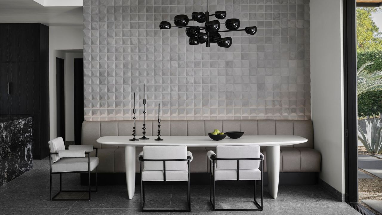 A large dining room with a tiled wall and dark decorative accents