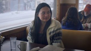 Tana (Lily Gladstone) sits in a diner in The Unknown Country