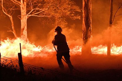 Fireman in Australia fights raging bushfire
