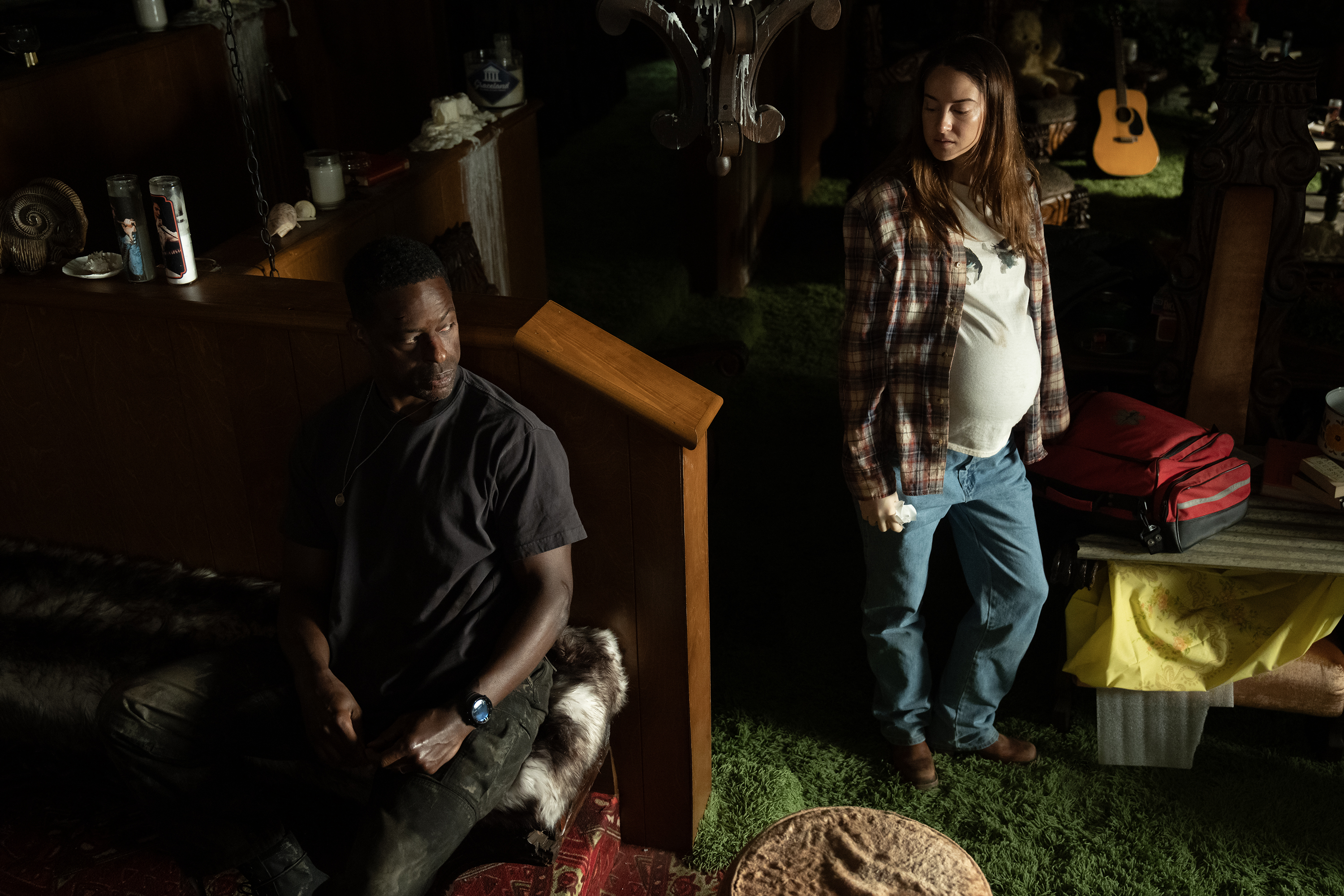 A man (Sterling K. Brown as Xavier Collins) sits on a couch in a dimly-lit carpeted room, as a woman (Shailene Woodley as Annie Clay) stands in a ray of sunlight. A still from 'Paradise' season 2.