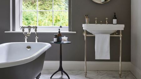 Gray bathroom with bathtub and white sink