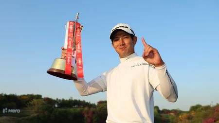 Keita Nakajima holds up his trophy and makes a number one sign with his other hands after the 2024 Indian Open